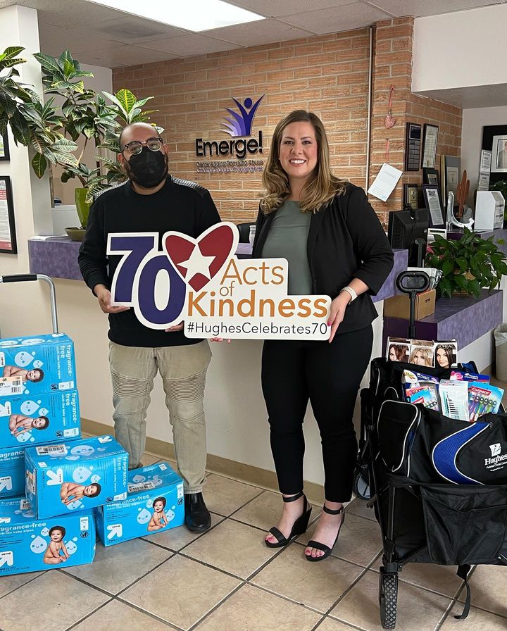 Emerge rep and branch manager pose with 70 acts sign