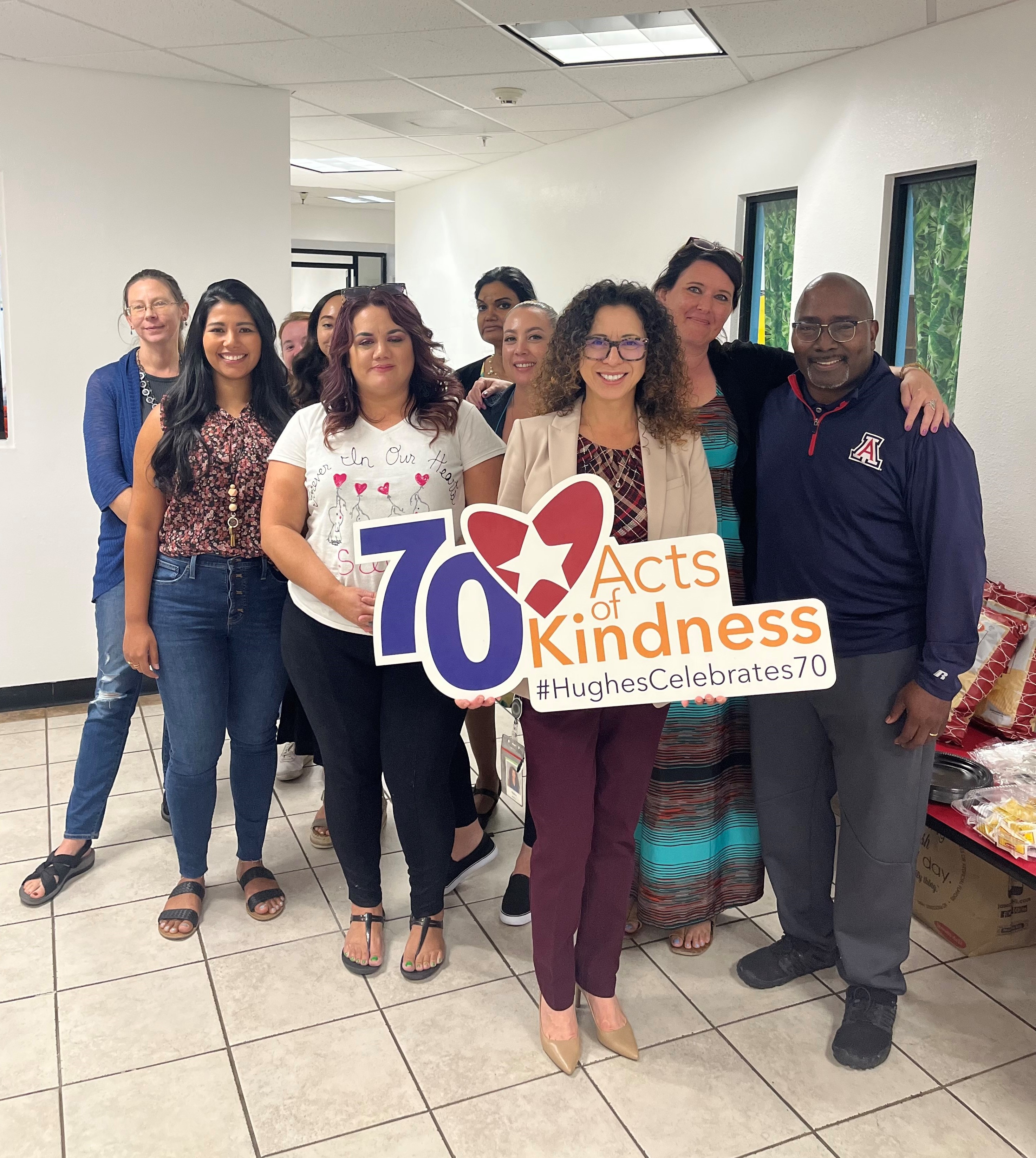 AmeriSchools staff and Hughes team pose with sign