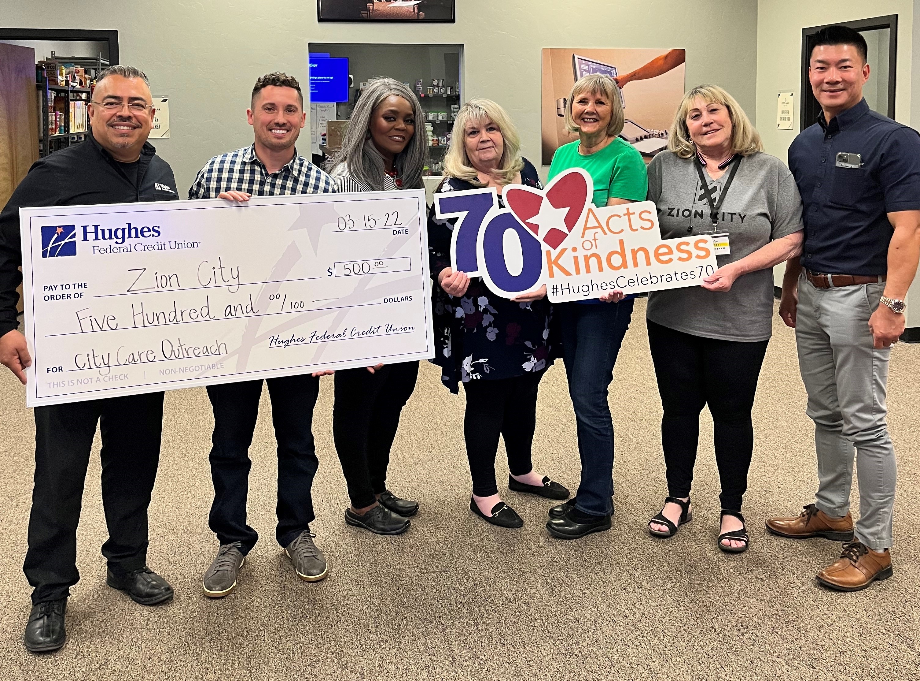 The Hughes team presents check to City Care Outreach