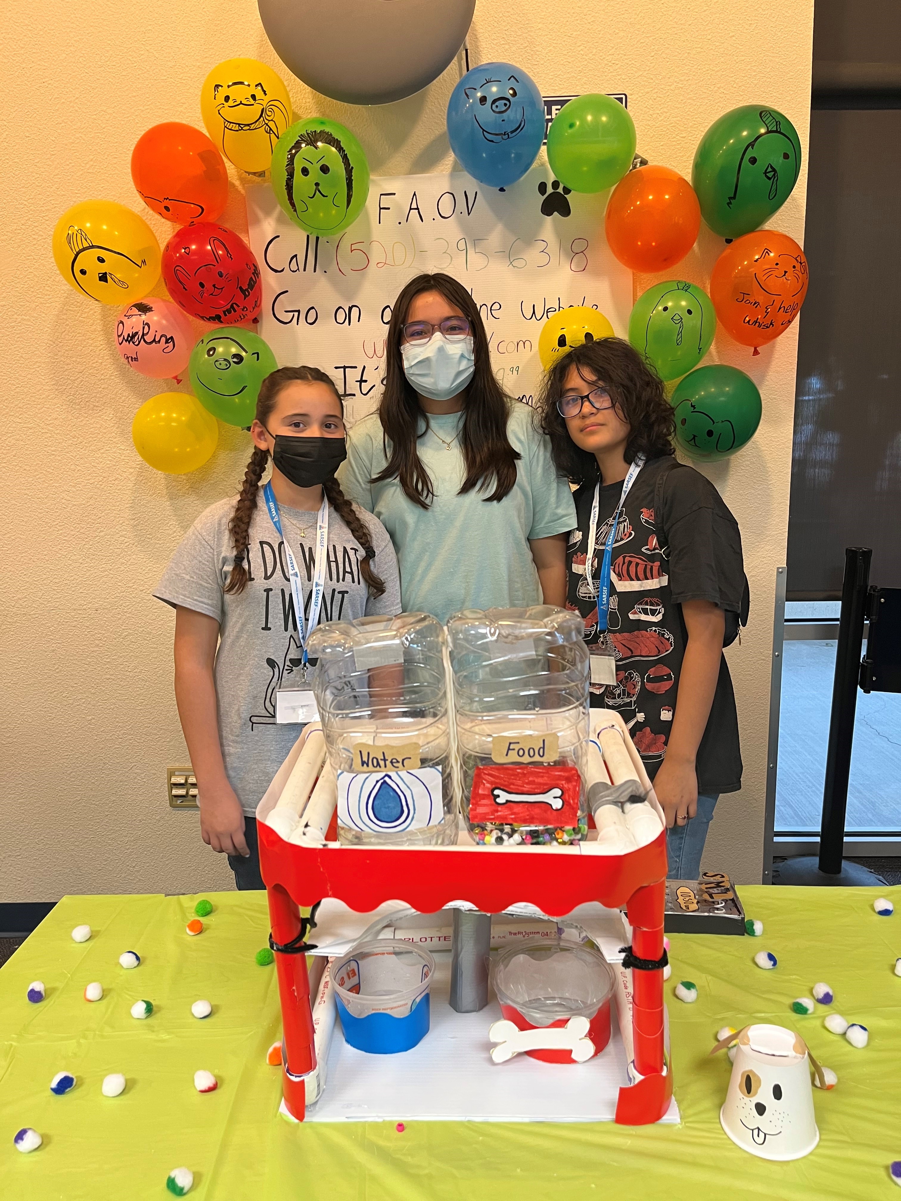 Students pose in front of science project