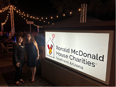 Hughes staff poses in front of RHMC logo