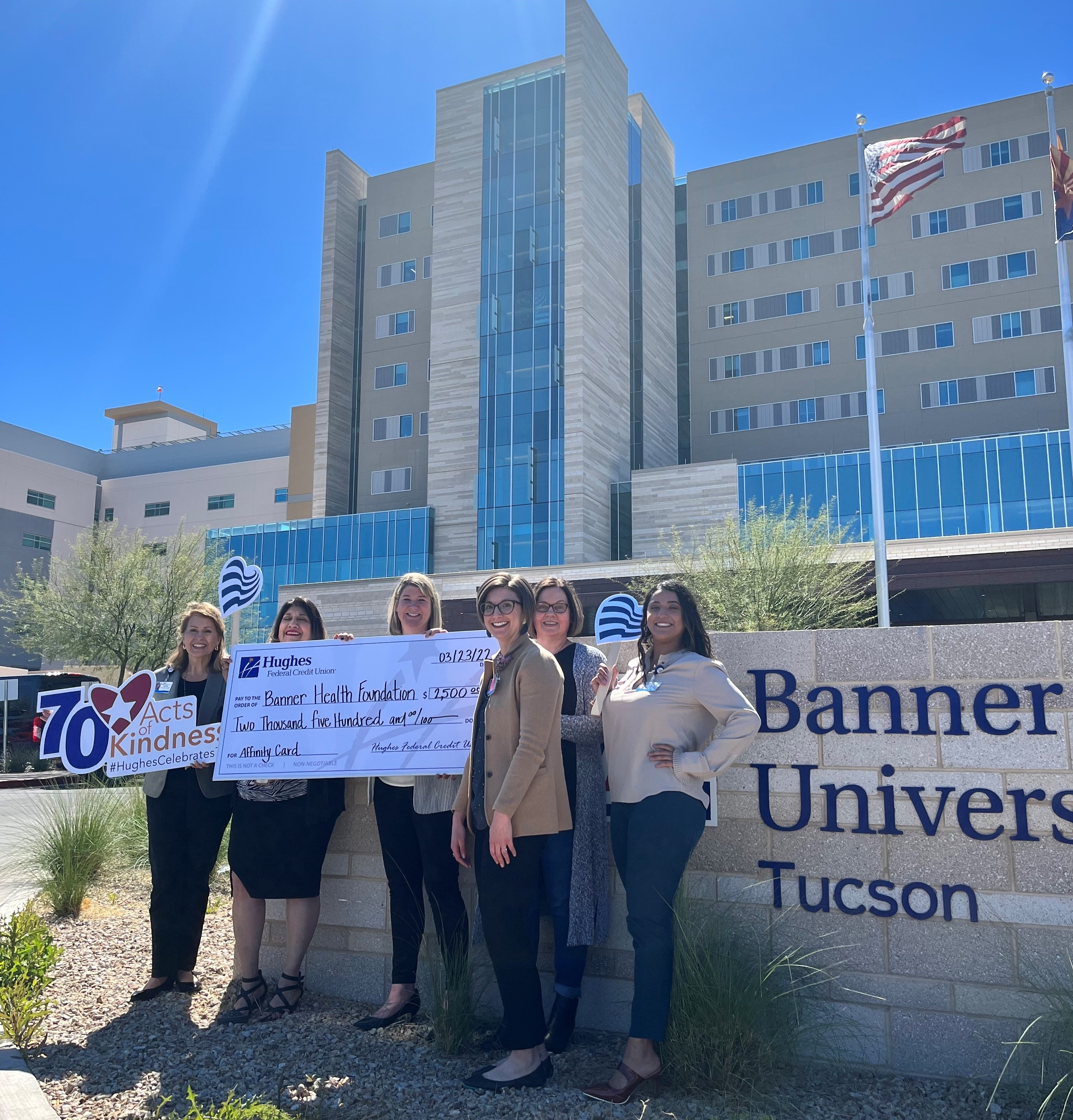 The Hughes team and Banner Health Foundation team pose for photo holding signs