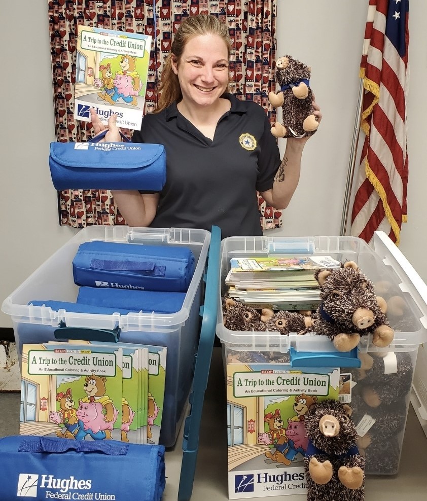 Woman holds a stuffed javelina a coloring book