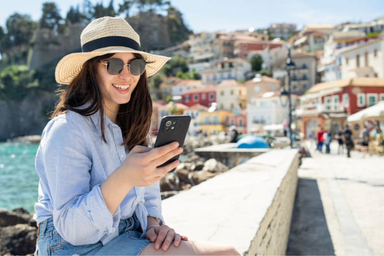 A young woman on vacation checks her phone.