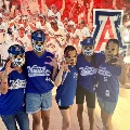 Family in front of Arizona softball team sign.