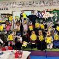 School kids with masks and books in classroom.
